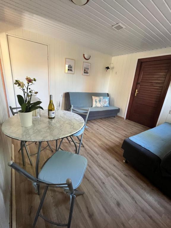 a room with a table and a couch and a bed at Beach House Mrzeżyno in Mrzeżyno