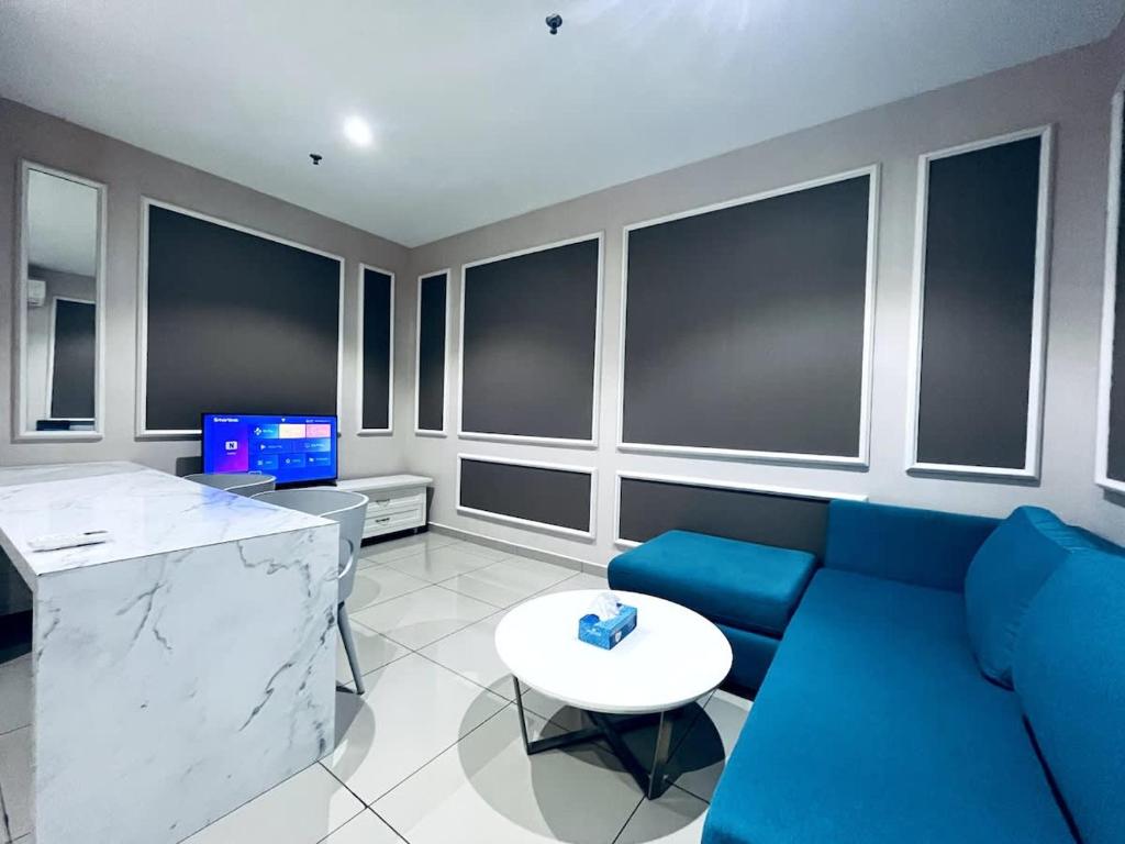 a living room with a blue couch and a table at Gem Homes at i-City - WiFi TV Box and 1 Carpark in Shah Alam