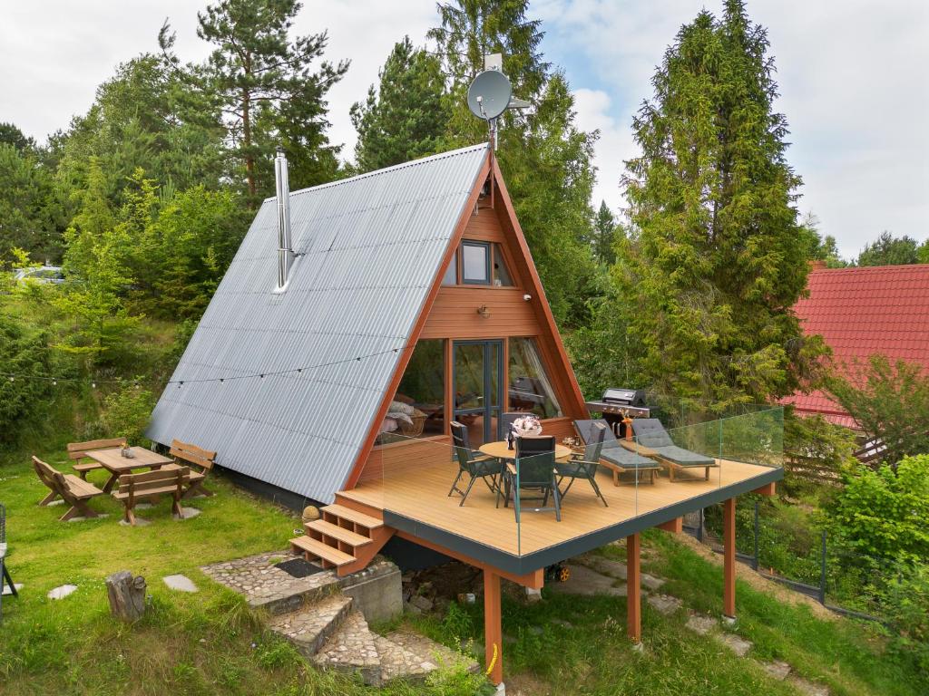 a tiny house with a pitched roof and a deck at Kaszuby Lake View in Żuromino