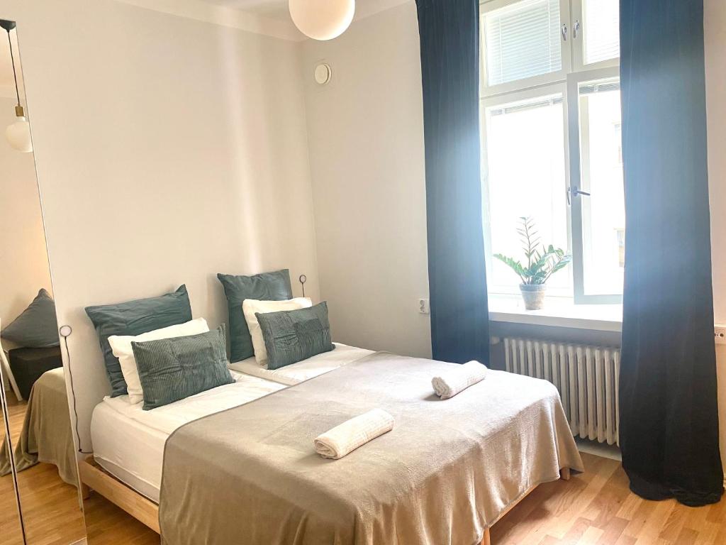 a bedroom with two beds with white sheets and a window at Simply chic Kamppi !NEW! in Helsinki