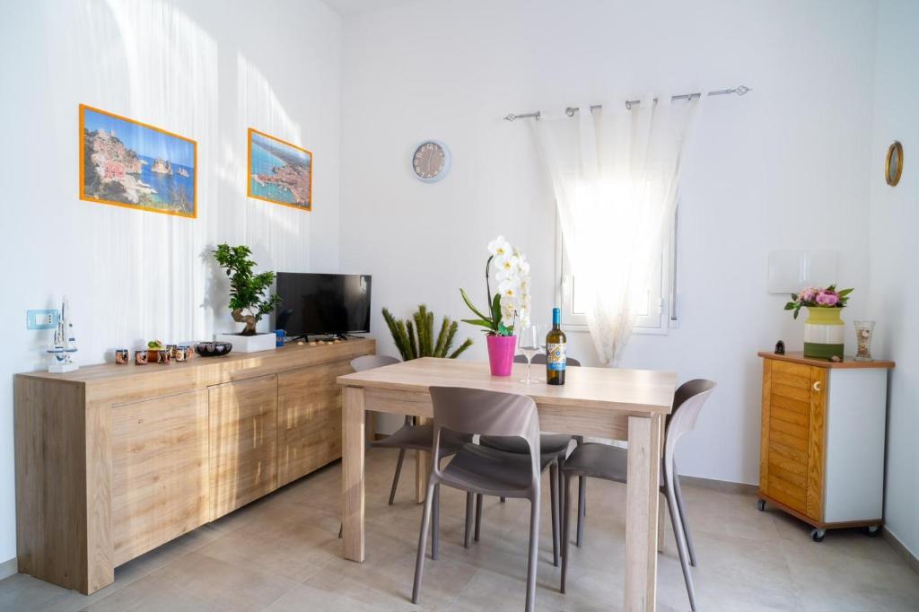 een eetkamer met een tafel en een tv bij Casa vacanze CaMi in Alcamo