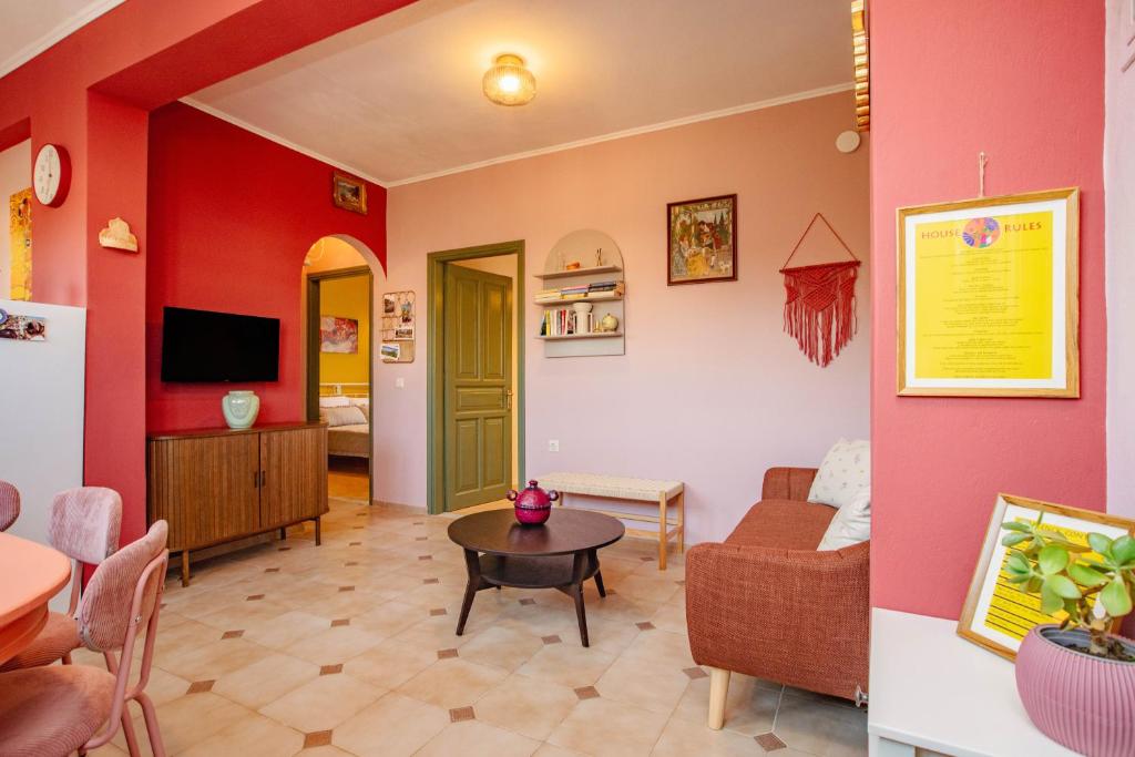 a living room with red walls and a table in a room at Yiayia's Guesthouse in Ipsos