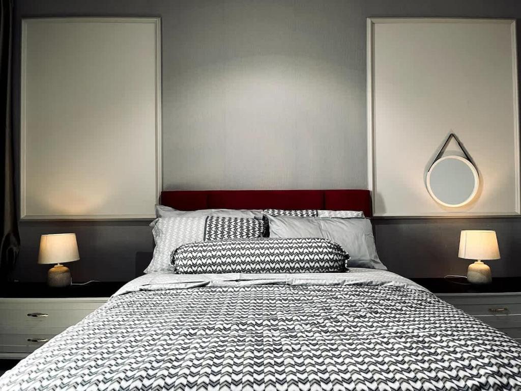 a bedroom with a bed with two lamps and a mirror at Maple Homes at i-City - WiFi TV Box and 1 Carpark in Shah Alam