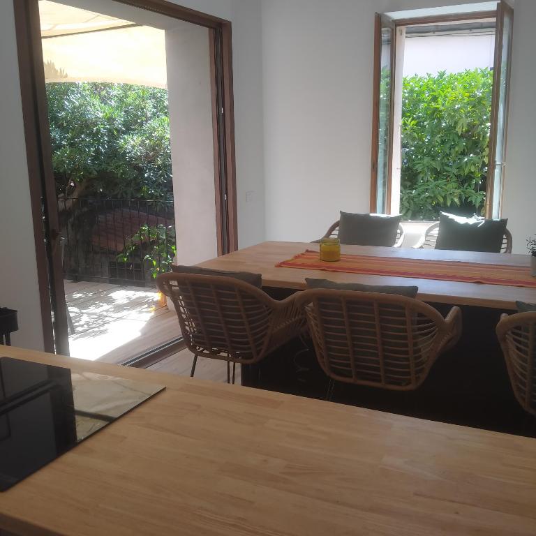 une salle à manger avec une table et des chaises et une fenêtre dans l'établissement Maison charme Collioure centre, à Collioure
