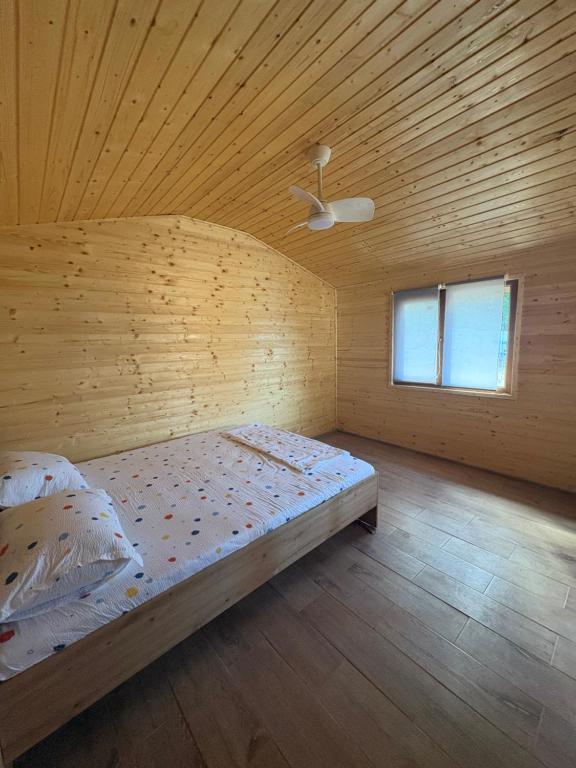a bed in a room with a wooden ceiling at Camping mery in Murighiol