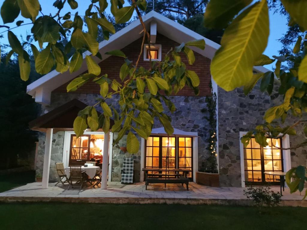 a stone house with a patio at night at VILLa ENRIETTe - Panoramic Mountain Retreat in Pano Platres, Cyprus in Kato Platres