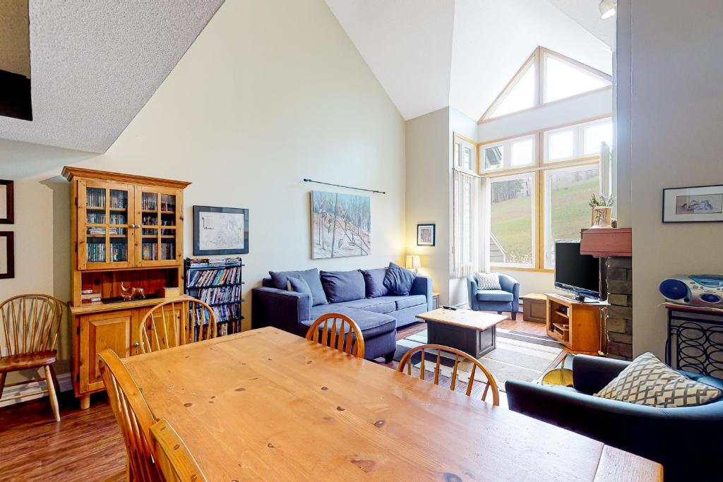Una sala de estar con un sofá azul y una mesa. en Chateau Ridge 209, en Blue Mountains