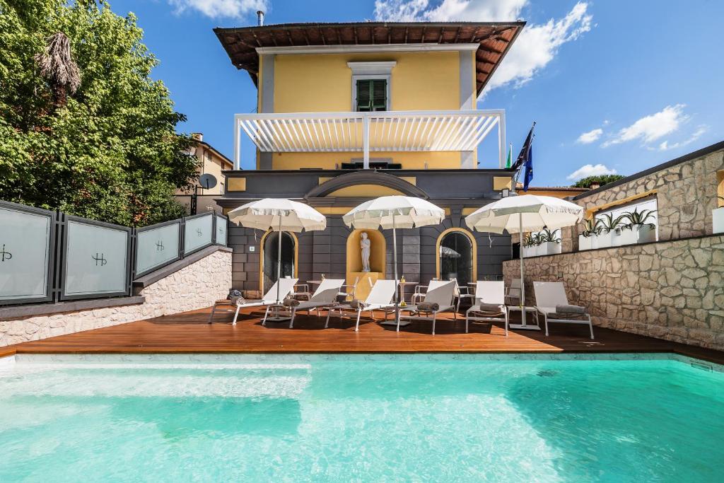 a house with a swimming pool with chairs and umbrellas at LHP River Club in Florence