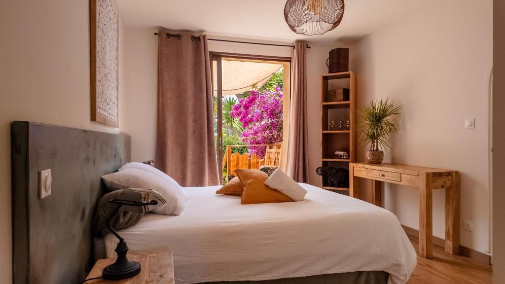 une chambre avec un lit blanc et une fenêtre dans l'établissement Chambre Canopée - maison exotique, à Hyères