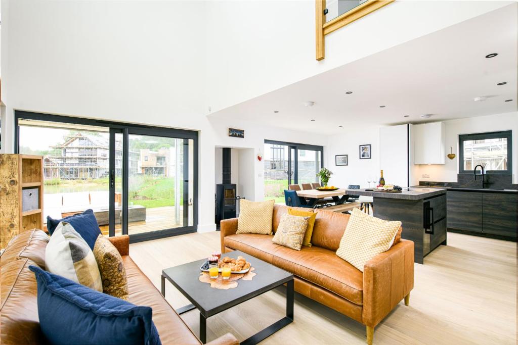 a living room with a couch and a table at The Cotswold Light House ML63 Lower Mill Estate in Somerford Keynes