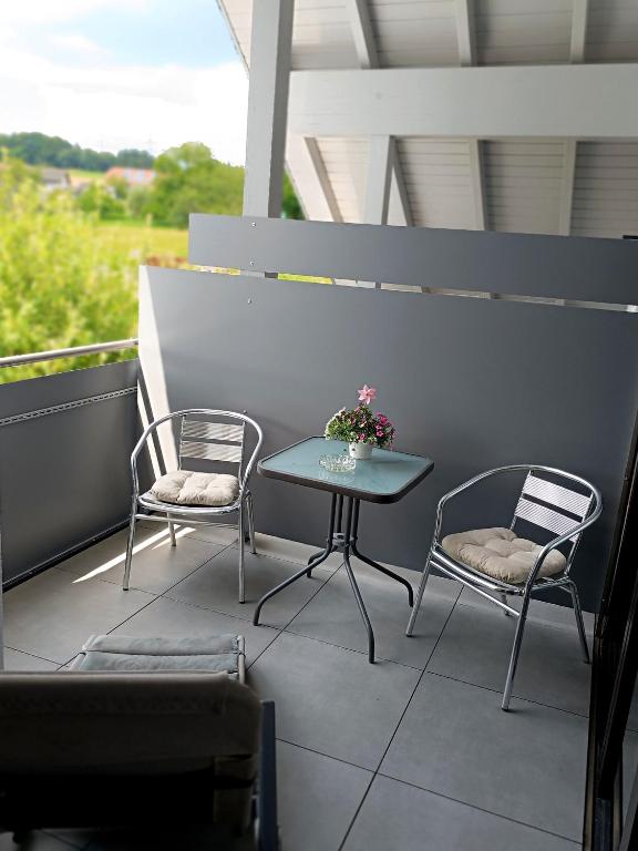 a patio with two chairs and a table on a balcony at 65 qm Ferienwohnung im Grünen in Albbruck