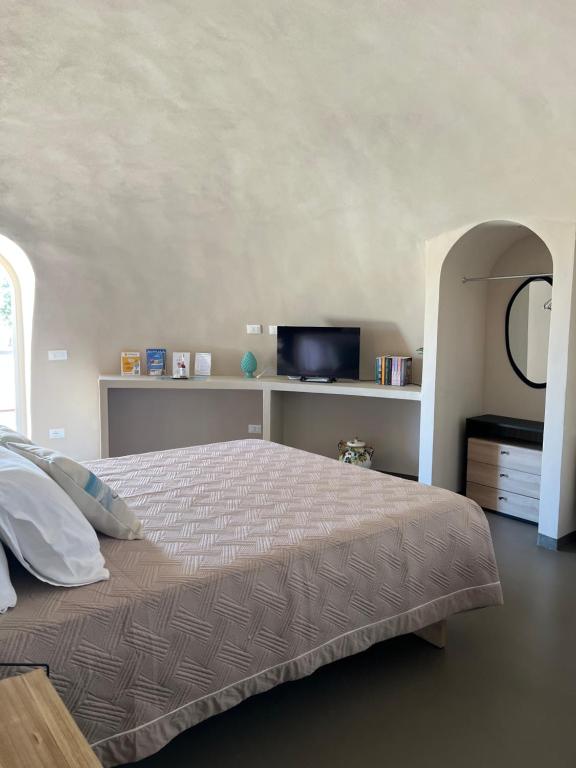 una camera con un grande letto e una TV di Nausicaa Guesthouse a Marsala