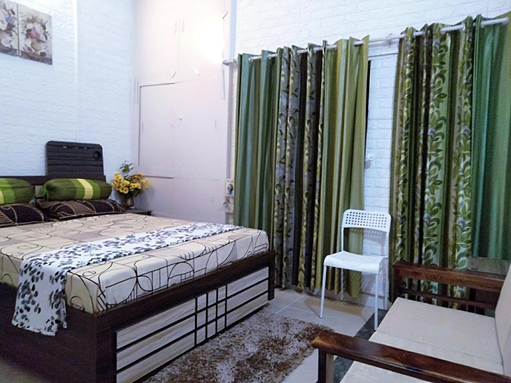 - une chambre avec un lit et des rideaux verts dans l'établissement Men-only COZYCORNER, à Lucknow