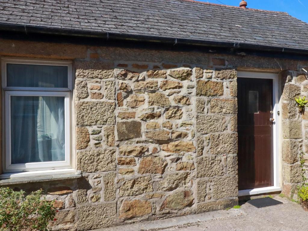 a stone house with a window and a door at Chyancrowse in Penzance