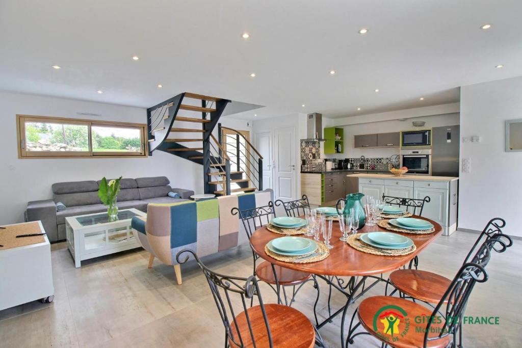 a kitchen and living room with a table and chairs at La grange in Ploeren