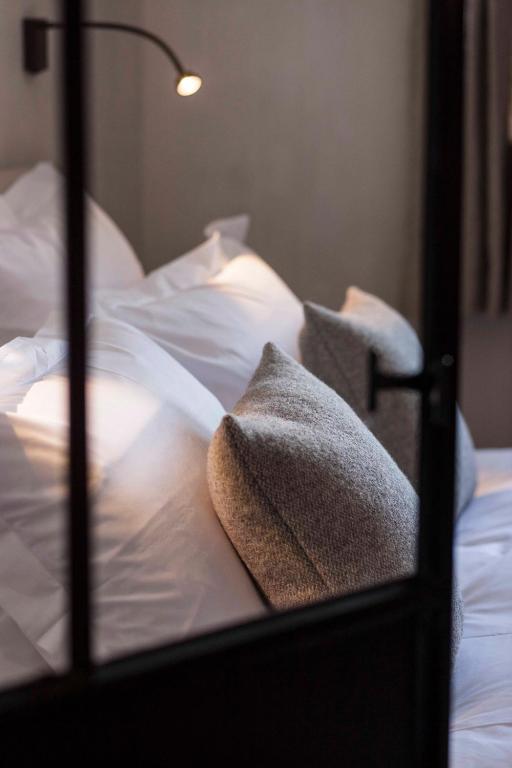 - un lit fermé avec des draps et des oreillers blancs dans l'établissement Appartement Flocon de Nell, à Megève