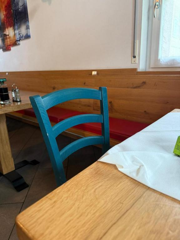 une chaise bleue assise à côté d'une table en bois dans l'établissement Lagorai, à Castello-Molina di Fiemme