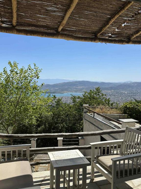 a patio with two chairs and a table and a view at Villa Stagiates in Stagiates