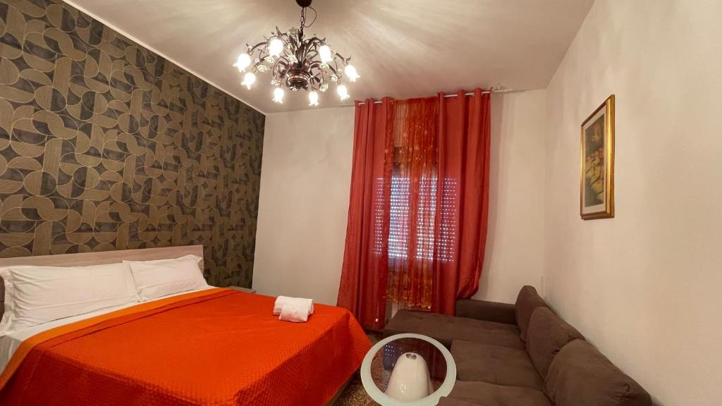 a bedroom with a red bed and a couch at Casa Amore a Bergamo in Bergamo