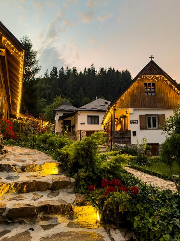 a house and a garden with flowers in front of it at Locul cu Amintiri in Albac