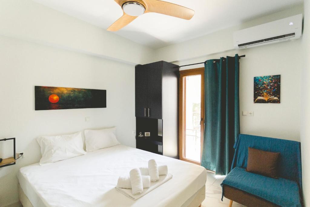 a bedroom with a bed and a blue chair at Alcentro Studio 2 in Platamonas
