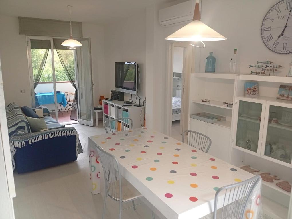 a living room with a table and a dining room at Baia 55 in Lido di Spina