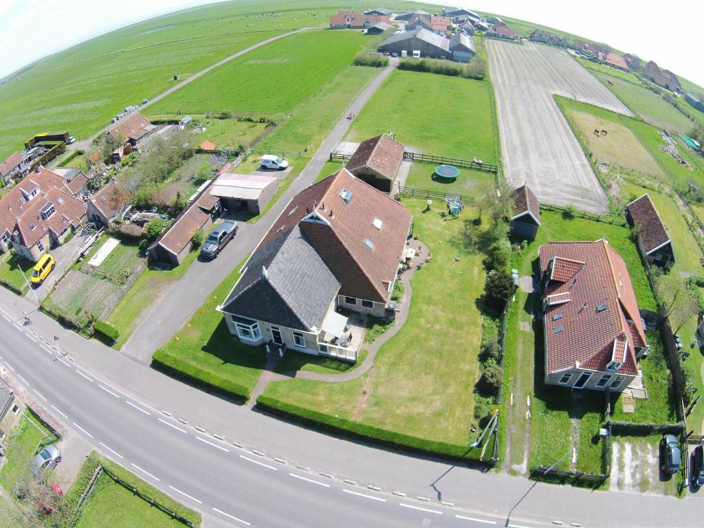 uma vista aérea de uma casa com uma estrada em vakantiehuis op terschelling em Baaiduinen