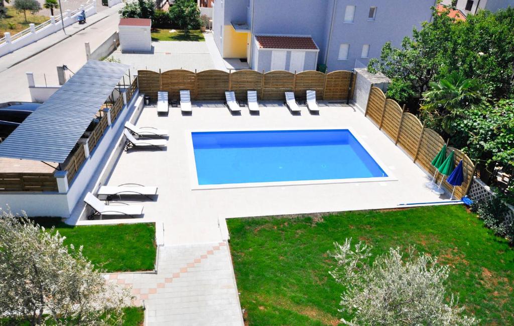 a swimming pool in a backyard with a lawn at Lovely Apartment In Novigrad in Karpinjan