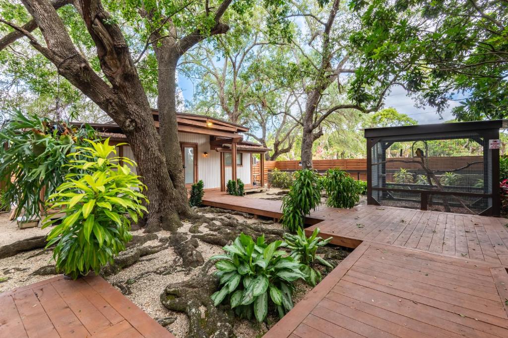 a house with a tree and a wooden deck at Serene Tiny House Retreat in Japanese Garden in Homestead