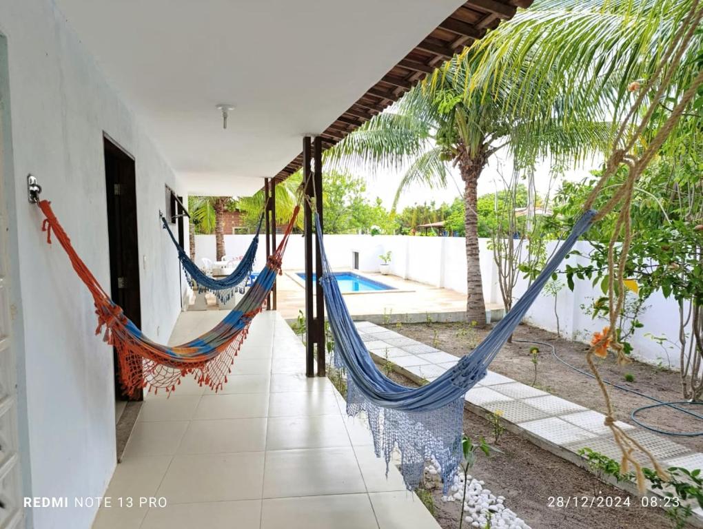 two hammocks in a house with a pool at Praia, piscina e churrasco in Itamaracá