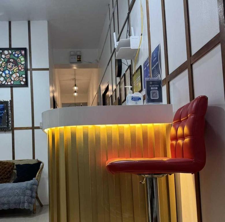 a bar with a red stool in front of a counter at OYO 1155 Carnivale Inn in Manila