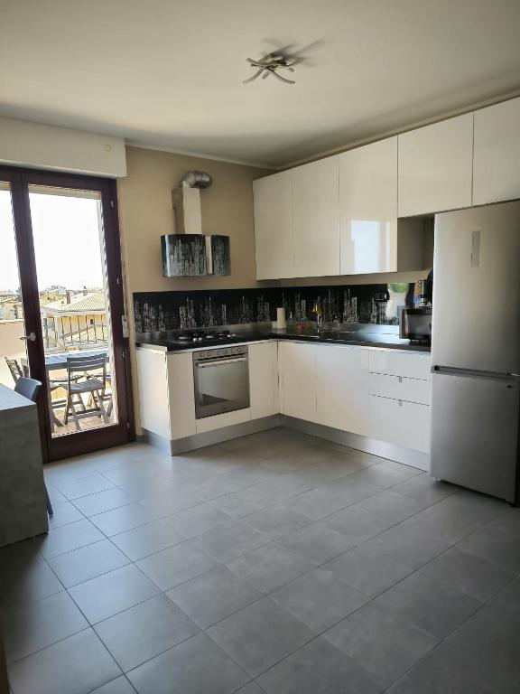 a kitchen with white appliances and a large window at Casa Cleo in Tortoreto Lido
