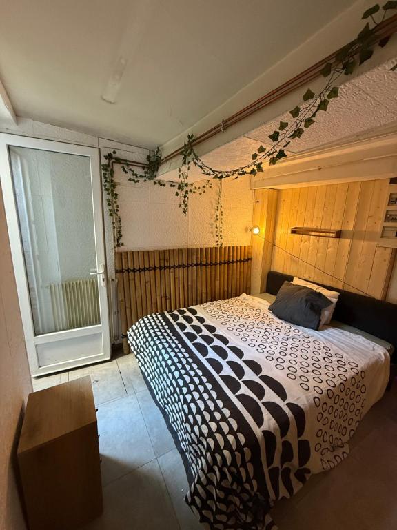 a bedroom with a bed with a black and white comforter at Appartement avec Jaccuzi & Jardin in Castres