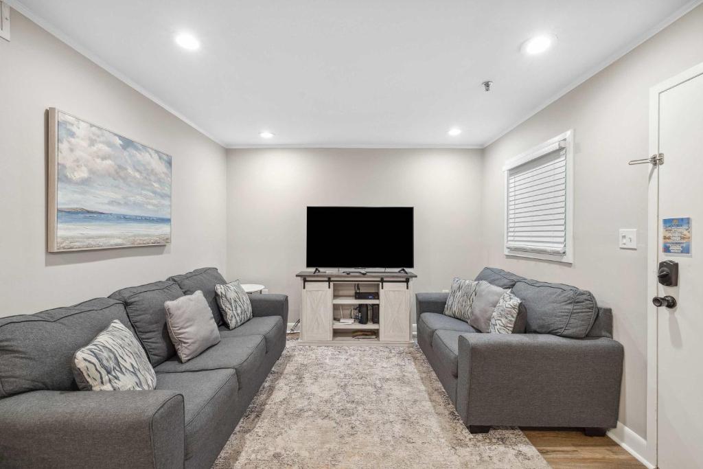 a living room with two couches and a flat screen tv at Ocean Breeze - Island Retreat for 6 in Hilton Head Island