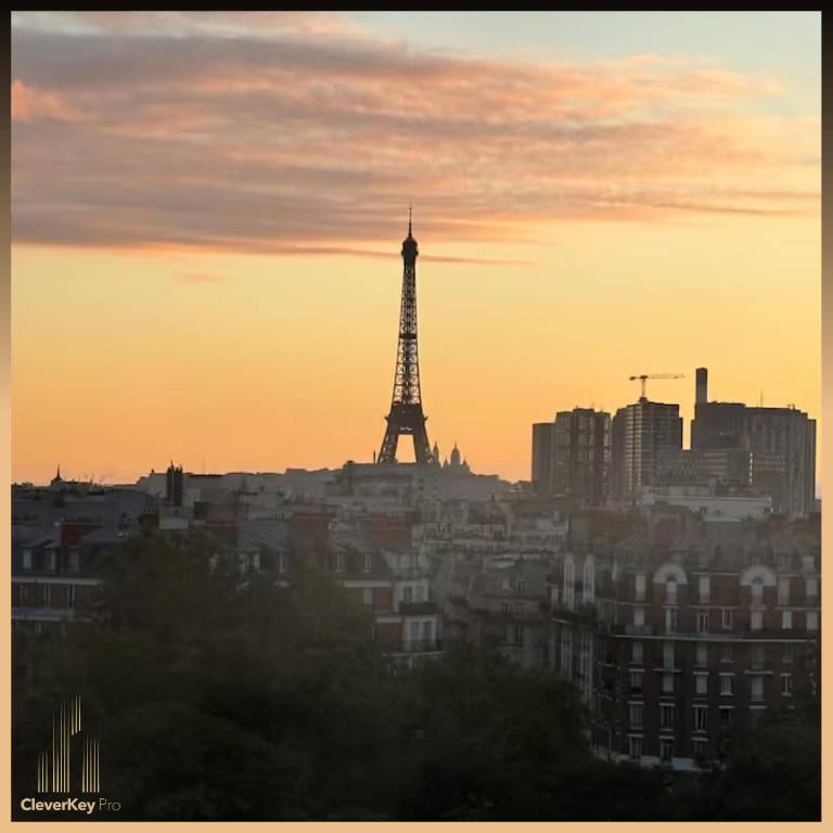 une ligne d'horizon avec la tour eiffel au coucher du soleil dans l'établissement Appartement vue sur TOUT Paris !, à Boulogne-Billancourt
