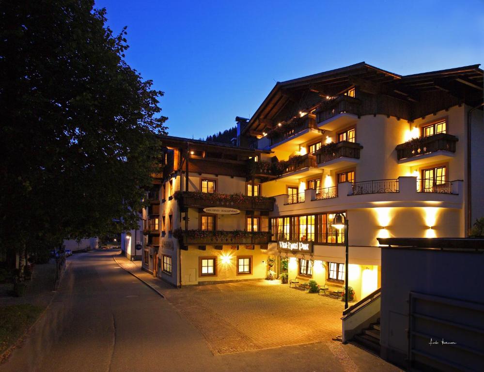 a large white building with lights on it at night at Vital Hotel Post in Dienten am Hochkönig