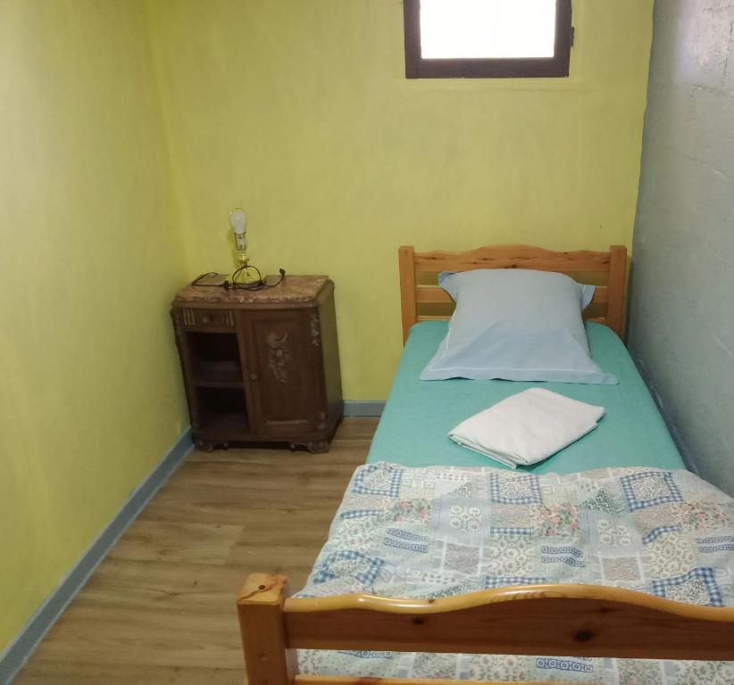 a small bedroom with a bed and a night stand at Maison accueillante à Montluçon avec jardin privatif in Montluçon