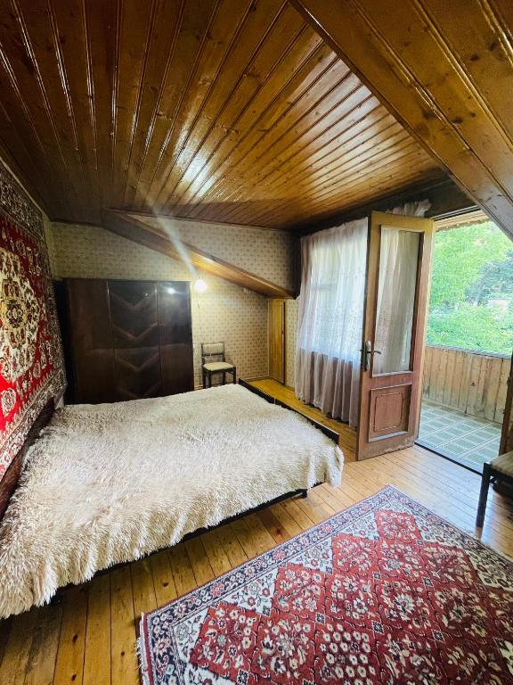 a bedroom with a large bed and a large window at Guest House Raisa in Dilijan