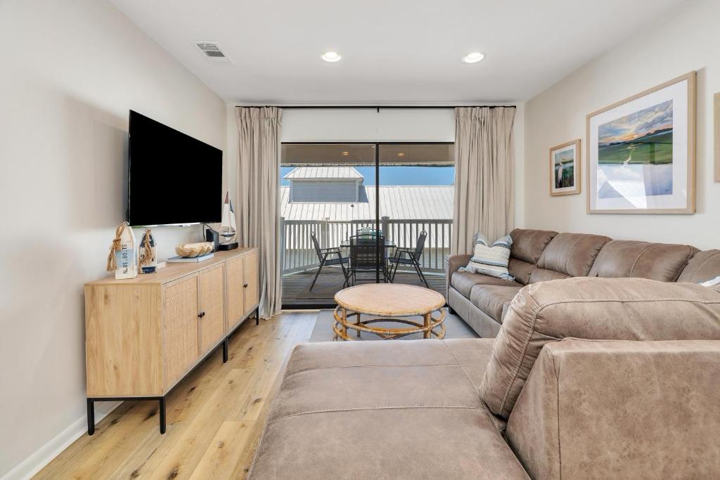 a living room with a couch and a flat screen tv at Shipwatch #311 in Saint Simons Island