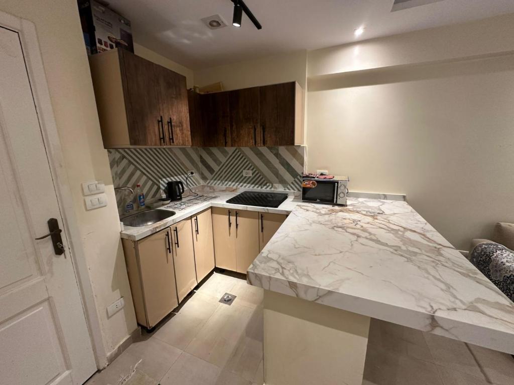 a small kitchen with a marble counter top at Chalet rozza in El Alamein