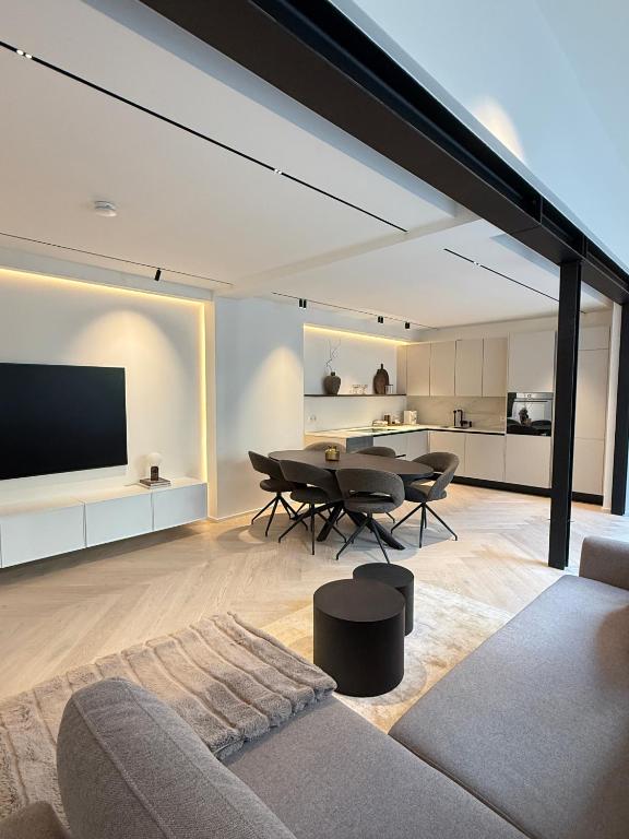 a living room with a table and chairs and a television at Innenstadt-Loft mit Terrassen-Oase in Memmingen