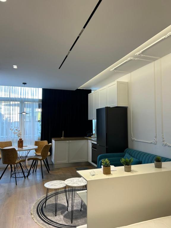 a kitchen and living room with a couch and a table at Alles Komuna studio apartment in Tirana