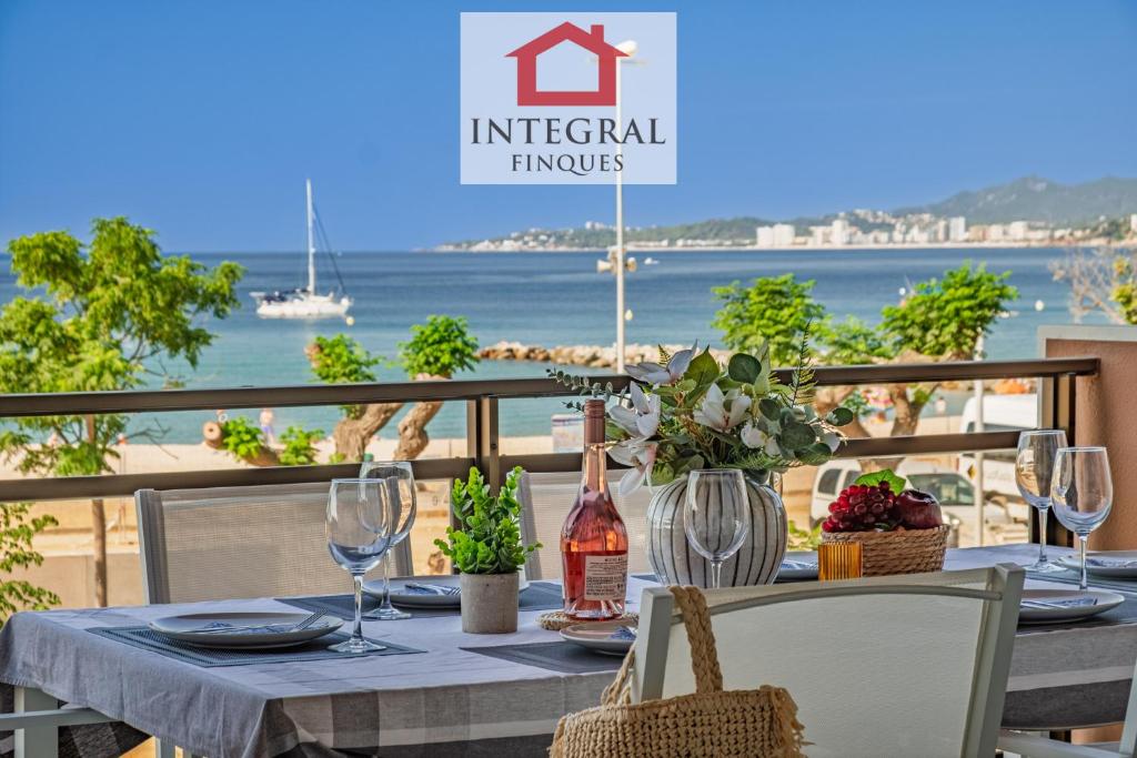 un tavolo con una bottiglia di vino e una vista sull'oceano di Apartament del Zenit a Palamós