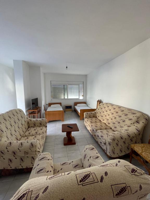 ein Wohnzimmer mit zwei Sofas und einem Tisch in der Unterkunft Lilis Apartments Sea view in Sarandë