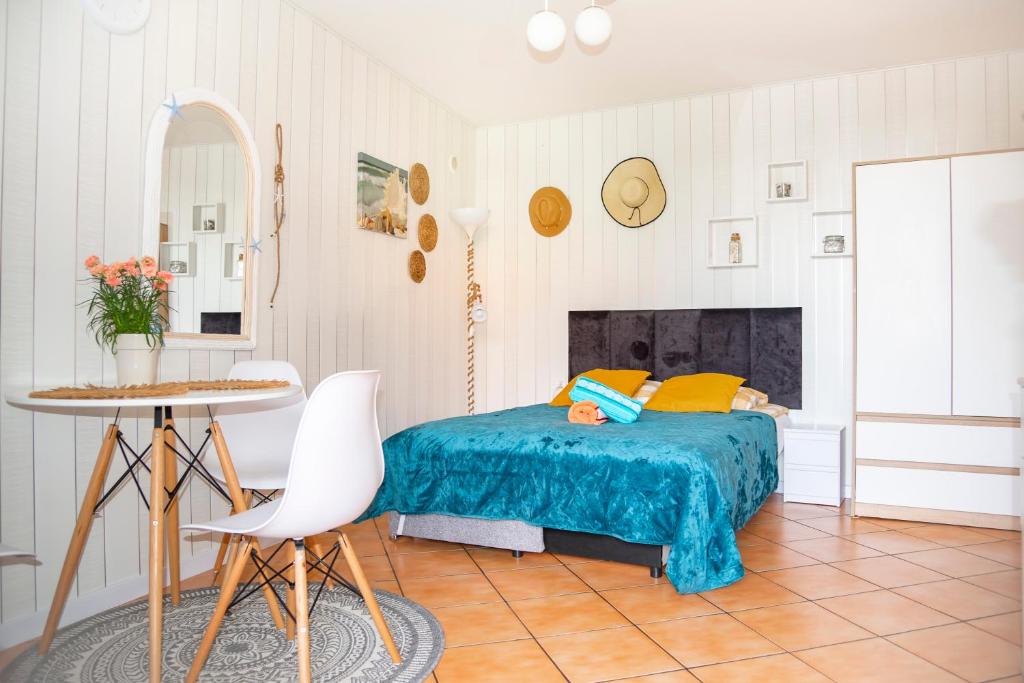 a bedroom with a bed and a table and chairs at Cała NAPRZÓD in Władysławowo