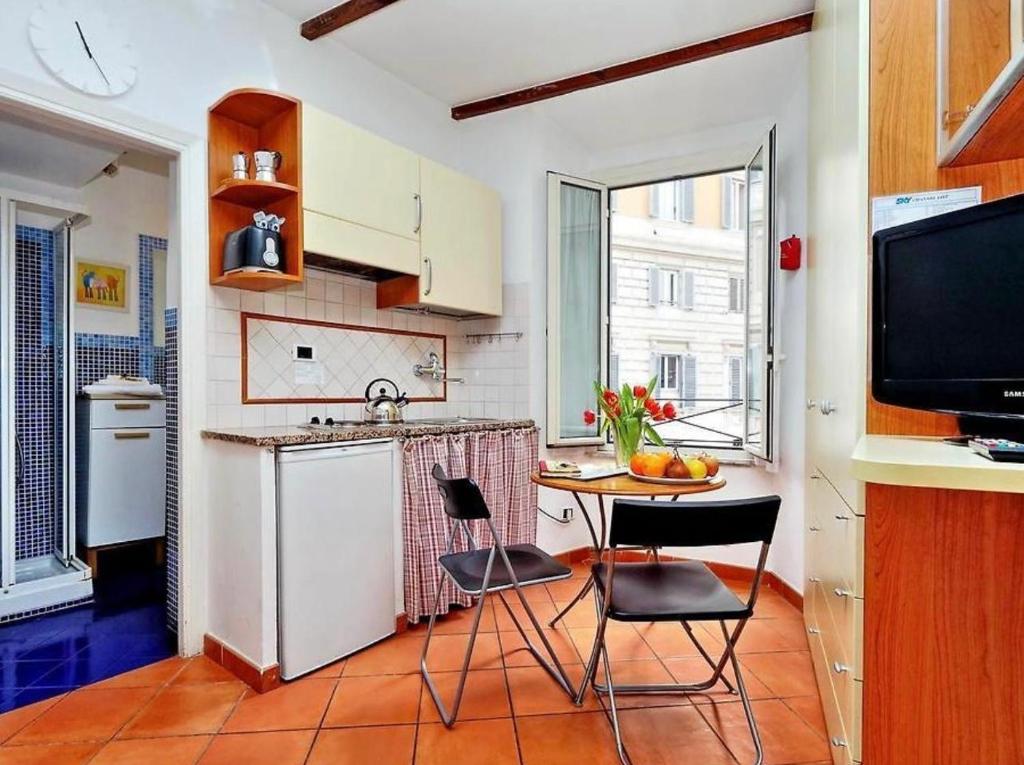 una cucina con tavolo, sedie e TV di 600mt To Colosseum a Roma