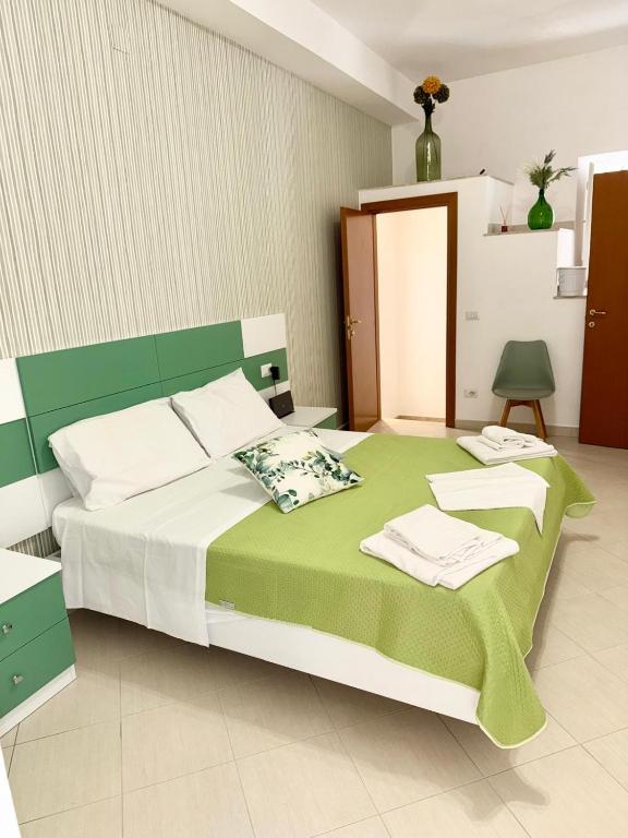 a bedroom with a green and white bed with towels on it at Maison Intarsio in Sorrento
