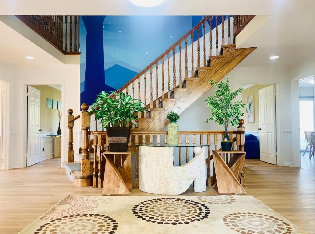 a living room with a wooden staircase and a blue ceiling at Amazing Unique House in Richmond Hill in Richmond Hill