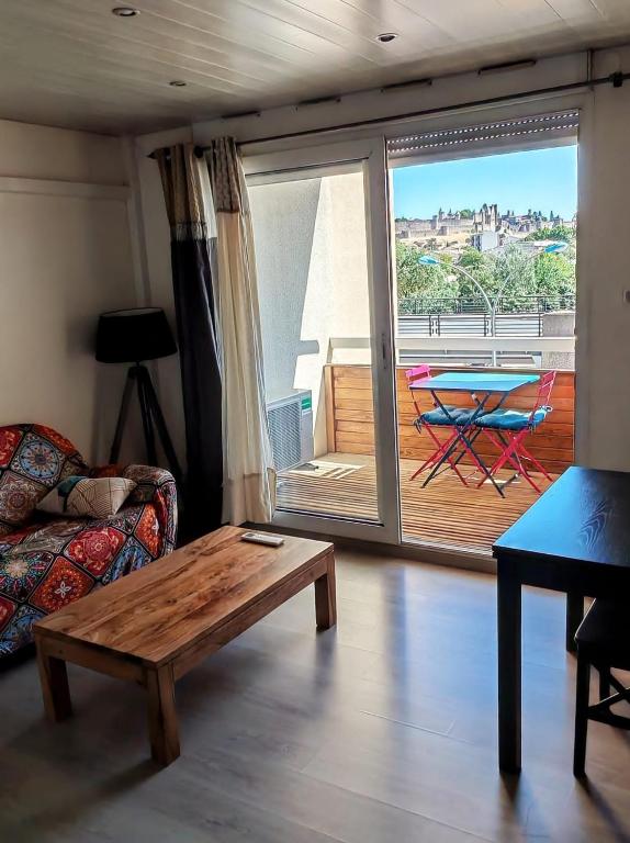Il comprend un salon avec une table basse et un balcon. dans l'établissement Le Balcon sur la Cité, à Carcassonne