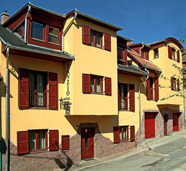 ein gelbes Gebäude mit roten Rollläden auf einer Straße in der Unterkunft Decsi Vendégház in Esztergom